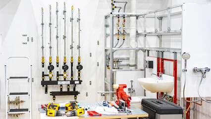 Engineering room in process installing equipment. Boiler system pipes in basement. Table and sink...