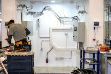 Electrical equipment repairman at work. Master of installation of energy networks. Male electrician is repairing transformer. Setting up engineering electrical networks. Guy near electrical panels