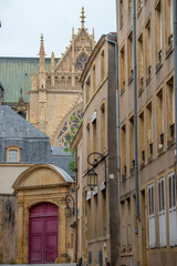 rue dui centre ville de Metz avec une porte coch&egrave;re en bois et le haut de la cath&eacute;drale au fond