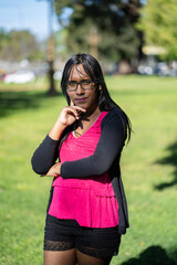 Latin transgender woman with thoughtful expression looking seriously at the camera