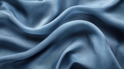 Naklejka premium Draped blue silk fabric with soft waves and folds.