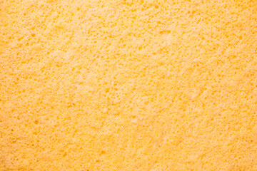 Close-up of a soft, textured yellow sponge cake surface,