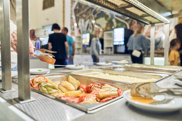 A woman's hand applies stuffed peppers. A buffet with Russian dishes, which features traditional dishes in metal containers. With space to copy. High quality photo