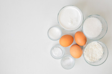 Baking ingredients like eggs, flour, and sugar are arranged on a white background, perfect for Easter baking ideas