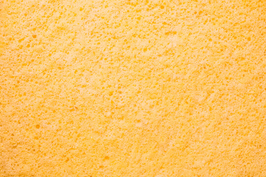 Close-up of a soft, textured yellow sponge cake surface,