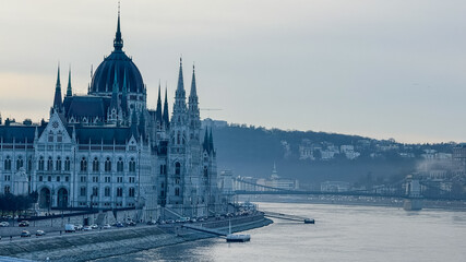 The scenic view of the Hungarian Parliament Building by the Danube River in Budapest symbolizes European heritage and architecture tourism