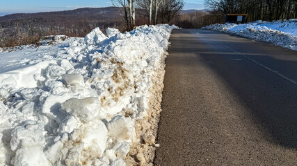 A snow-covered rural road in winter highlights transportation challenges and the beauty of nature...