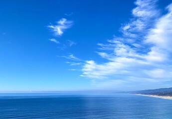 Obraz premium Serene Coastal Landscape: Ocean View with Blue Sky and White Clouds