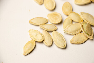 A handful of pumpkin seeds displayed against a white , emphasizing their natural texture, nutritious appeal, and suitability for healthy eating or cooking concepts