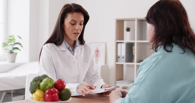 Nutritionist doctor provides advice to the patient, formulating a diet plan. The consultation focuses on discussing the benefits of nutritious vegetables into the patient dietary choices.