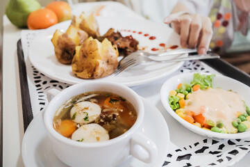 Female adult patient at hospital reaching her healthy dietary meals menu served on a tray from bed