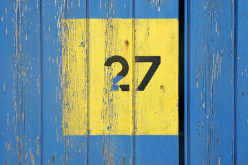 27 number painted  on a yellow wooden texture