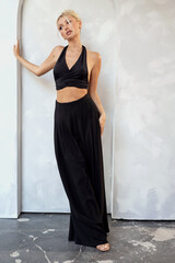 Young attractive blonde fashion model posing on studio background,