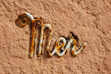 Mer  metal rusty letter on ochre wall