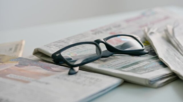 A close up of the glasses on the newspaper.