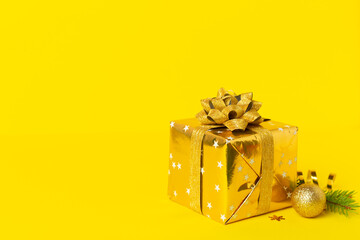 Golden gift box with christmas decor on color background