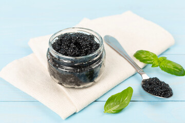 Jar with black caviar on on wooden table