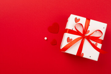 Gift boxes with red hearts on color background, top view