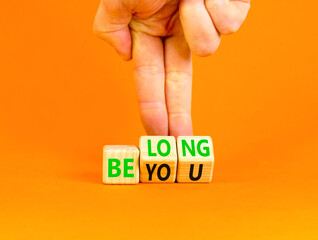 Belonging and belong symbol. Concept words Be you Belong on beautiful wooden block. Beautiful orange background Businessman hand. Business motivational belonging and belong concept. Copy space.