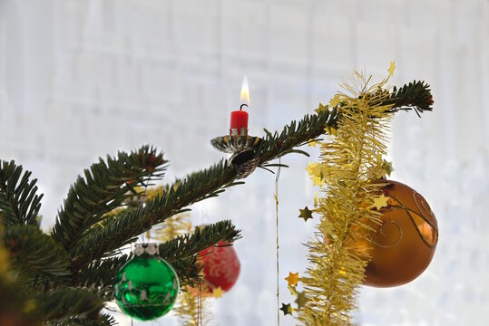 Christbaumkugeln und brennende Christbaumkerze - Detail