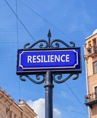 Obraz premium Resilience symbol. Concept word Resilience on beautiful blue road sign. Beautiful blue sky and city building background. Business resilience concept. Copy space.