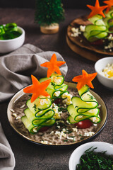 Christmas trees made of cucumber and cherry tomatoes on skewers on a plate vertical view