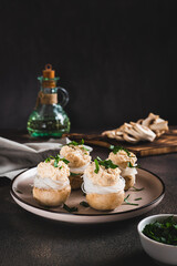 Appetizer of champignons, funchose and capelin caviar on a plate on the table vertical view