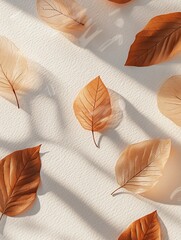 Autumn leaves arranged on a beige background with sunlight shadows.