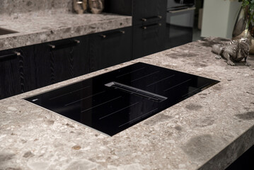 Induction hob with integrated extractor on stone countertop, modern design