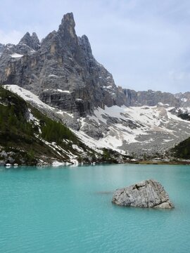 lago turquesa y monta&ntilde;a al fondo nevada dolomitas