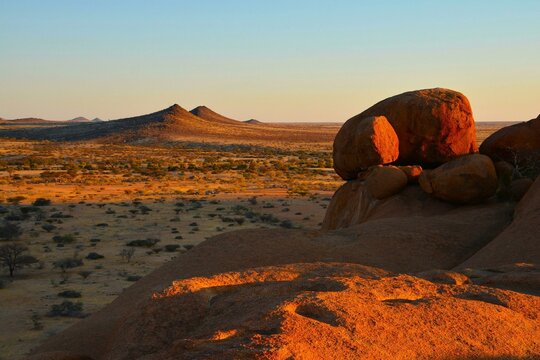 Sunset scenery of the plains surrounding Spitzkoppe, "Matterhorn of Namibia" - a group of bald granite peaks located between Usakos and Swakopmund in the Namib desert (Namibia)