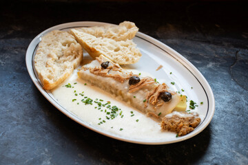 Pancakes that tuna, duck or chicken served with bread and spices on dark stone, with white cheese sauce