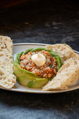 salmon tartar tapas with avocado and slices of bread