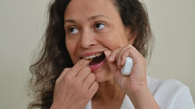 Woman flossing her teeth as part of a daily dental health routine