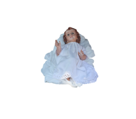 Baby jesus figurine lying down on white cloth with transparent background