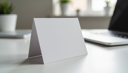 Blank card on a desk beside a laptop inviting creativity and personal expression in an inspired workspace