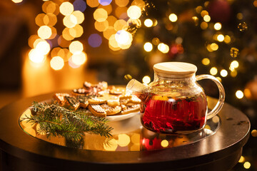 aromatic winter tea from currant berries, lemon and next to it gingerbread cookies for Christmas on a dark background.