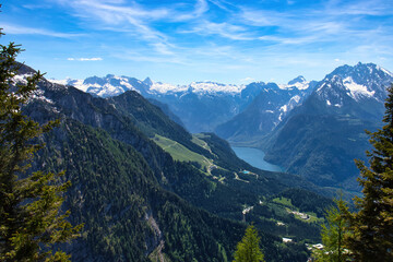 Obraz premium Mountains with green trees and snow on top surrounding Konigssee in a valley on a spring day at the Eagle's Nest in Bavaria, Germany.