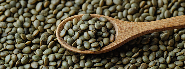 Obraz premium A wooden spoon filled with green pumpkin seeds, resting on top of an endless pile of the same seeds.
