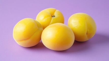 Fresh ripe yellow apricots arranged on a pastel lilac backdrop showcasing their vibrant color and natural texture.