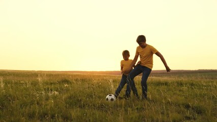 happy family sunset. group people playing soccer with soccer ball. boys play football with their father. child kid run around field kick ball with their foot. children play green field with brothers