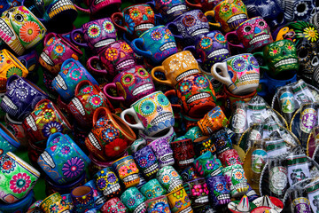 Fototapeta premium Street sale of handicrafts alluding to the Day of the Dead in Mexico City. Cups decorated with colorful skulls.