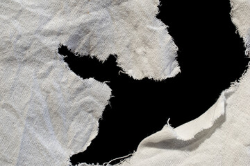 torn old white rag with holes on a black background