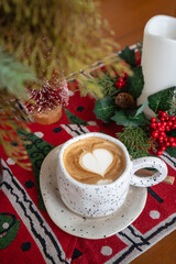 Close up of Hot coffee latte with latte art milk foam in cup mug with Xmas decors and Xmas tree baubles on wood desk Celebrating Merry Christmas and New year,Merry x-mas