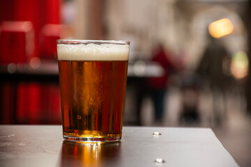 craft beer with foam served on street table in El Tubo alley in Zaragoza in Spain with blurred background