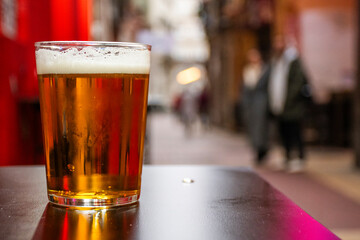 craft beer served on street table in El Tubo alley in Zaragoza in Spain with blurred background