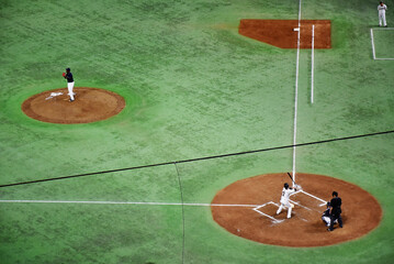 Baseball players in action on a mound, surrounded by green turf, showcasing the intensity and skill of the game. Famous Japanese national sport.