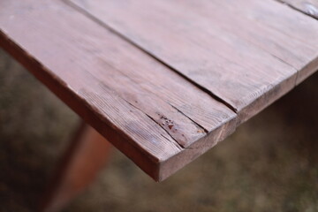 Close-up of a wooden table surrounded by green grass, suitable for outdoor or nature-inspired scenes.