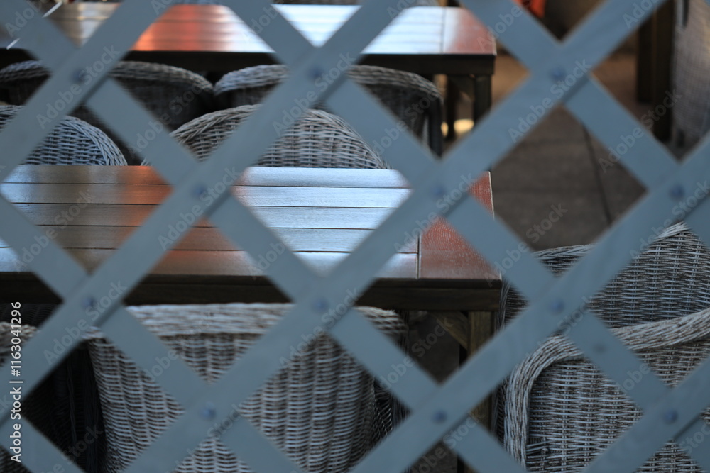 Poster a cozy dining setting with a wooden table and wicker chairs.