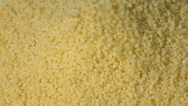 Close-up of yellow dry couscous, top view. a background with space to copy. The concept of vegetarian ingredients for vegans. Another name is Cuscus or Cuz Cuz